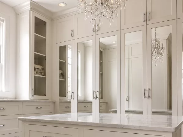 Walk-in closet island with Carrara marble countertop and mirrored cabinet doors installed by TopSouth Countertops and Closets in Marietta, GA