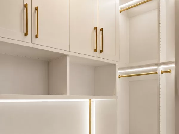 Custom closet system with brass hardware, LED-lit shelving and built-in drawer storage by TopSouth Countertops and Closets in Marietta, GA