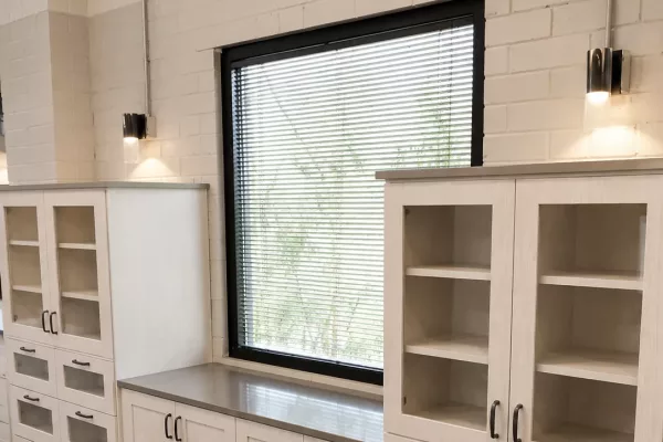 Custom storage cabinets with glass doors and quartz countertops in a commercial space by TopSouth Countertops and Closets in Atlanta, GA