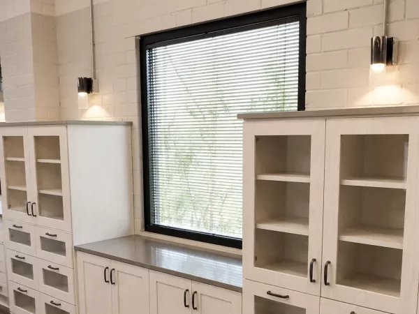 Custom storage cabinets with glass doors and quartz countertops in a commercial space by TopSouth Countertops and Closets in Atlanta, GA