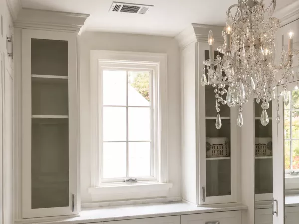 Custom dressing room cabinetry with marble countertops and crystal chandelier lighting by TopSouth Countertops and Closets in Marietta, GA