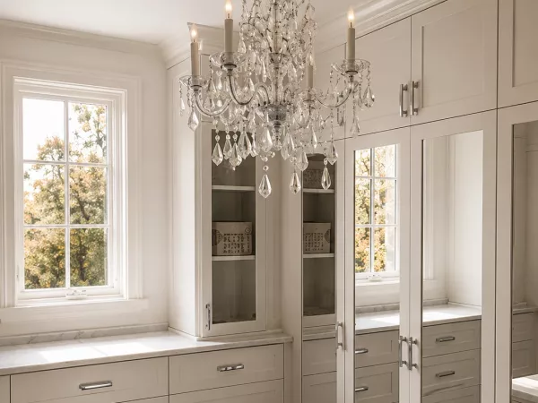 Luxury dressing room closet with Carrara marble island and crystal chandelier by TopSouth Countertops and Closets in Atlanta, GA
