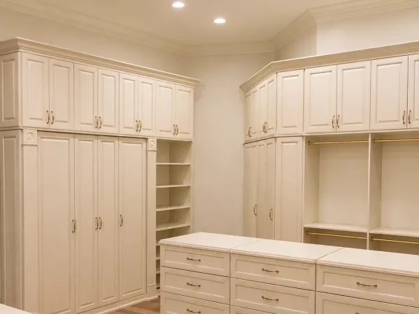 Luxury walk-in closet with built-in cabinets and quartz-topped drawer island by TopSouth Countertops and Closets in Atlanta, GA