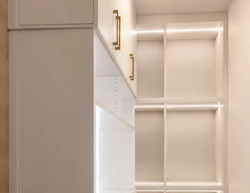Modern custom closet system with LED-lit open shelving and brass hardware by TopSouth Countertops and Closets in Atlanta, GA