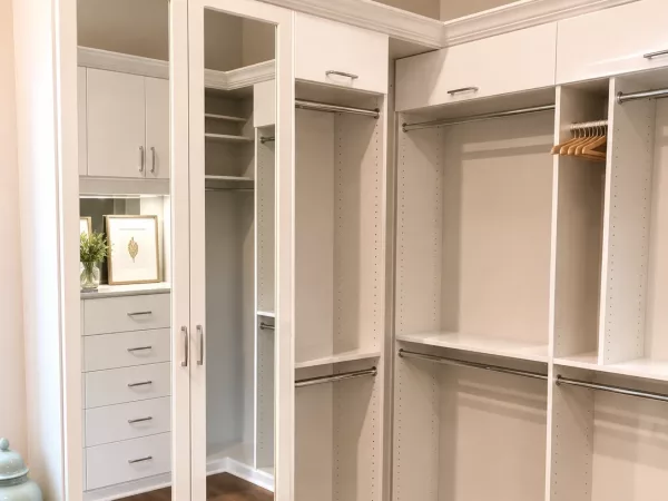 Custom reach-in closet organizer with mirrored doors and adjustable shelving by TopSouth Countertops and Closets in Marietta, GA